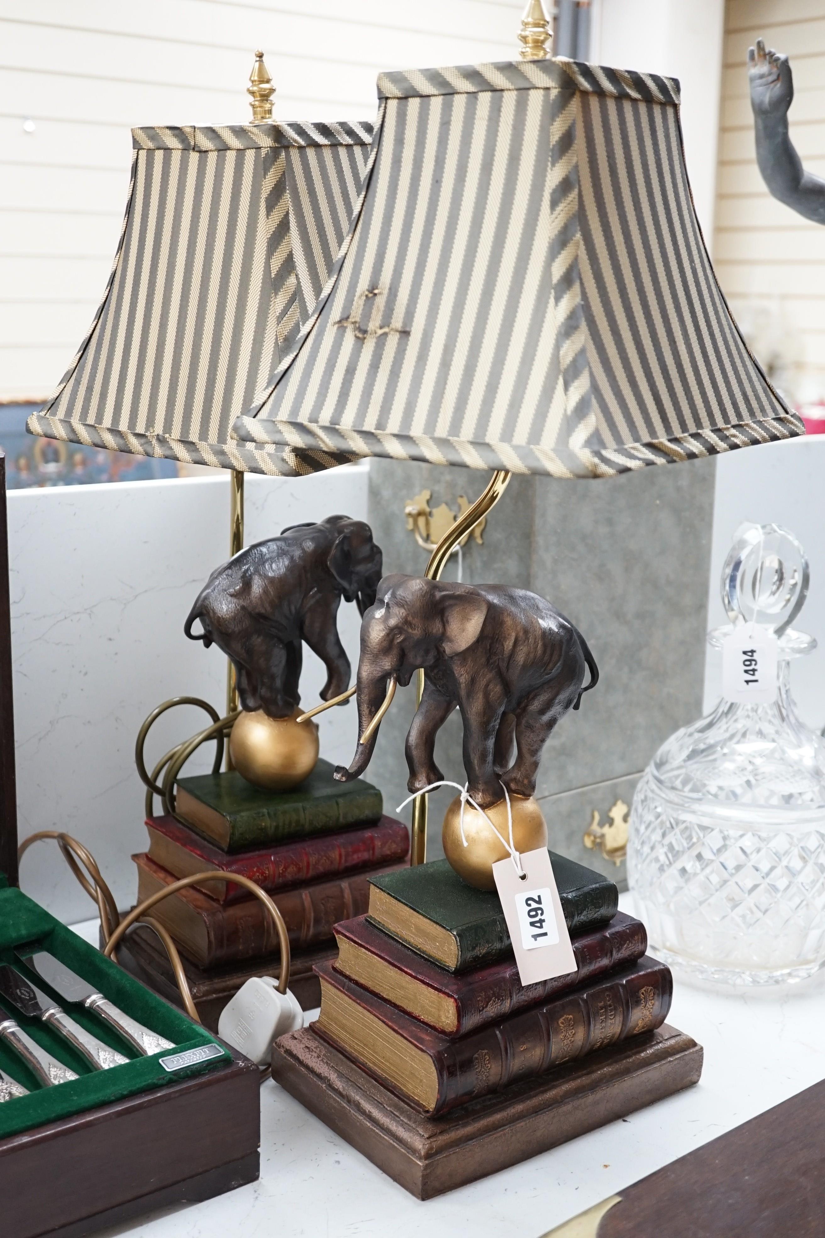 A pair of novelty table lamps: elephants balancing on balls on books, 63cms high